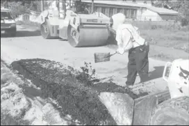  ??  ?? A Ministry of Public Infrastruc­ture worker laying asphalt along one of the damaged parts of the road yesterday afternoon.