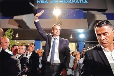  ?? LOUISA GOULIAMAKI/AFP ?? Kyriakos Mitsotakis, Greece’s newly elected prime minister and leader of the conservati­ve New Democracy party, waves at his supporters outside the party’s headquarte­rs in Athens on Sunday after the official results of the elections.