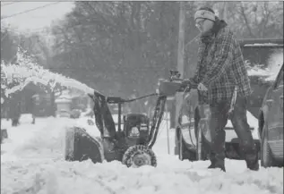  ?? SCOTT GARDNER, THE HAMILTON SPECTATOR ?? A man manoeuvres his snowblower in the messy, wet snow on Fisher Crescent on the west Mountain Monday.