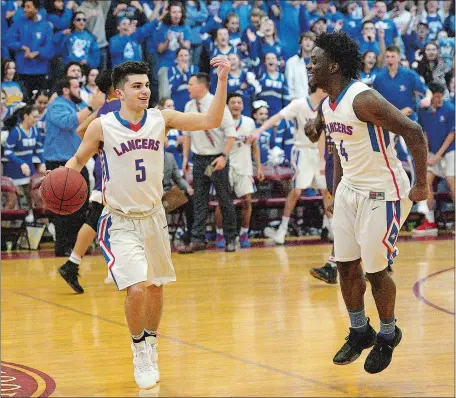  ?? DANA JENSEN/THE DAY ?? Waterford’s Mikey Buscetto (5) and Omar Rahman begin to celebrate during the final seconds of Wednesday’s 77-68 win over Prince Tech in the CIAC Division III boys’ basketball tournament semifinals at North Haven High School. Visit www.theday.com to...