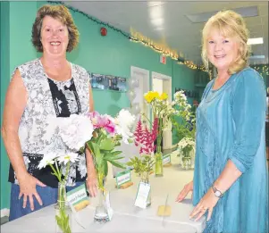  ?? JEREMY FRASER PHOTOS/CAPE BRETON POST ?? Patsy MacKenzie, front, and Margaret Buffet are pictured with a group of flowers during the 50th annual North Sydney Garden Club Rose and Flower show at the Royal Canadian Legion in North Sydney on Tuesday. The show featured 95 entries.