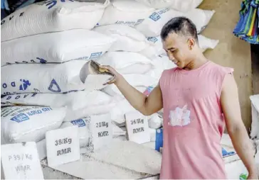  ?? IAN PAUL CORDERO/PN ?? A vendor at the Iloilo City Terminal Market checks the quality of the rice he’s selling.