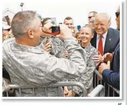  ??  ?? Hard to tell if Trump is smiling or wincing in agony as he takes photos with military personnel in Long Island. AP