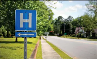  ?? Associated Press file photo ?? A sign points the way to a hospital in Georgia. A study shows that medicare patients with common illnesses who were treated by their own familiar primary care doctors were slightly more likely to survive after being sent home than those treated by...
