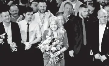  ??  ?? Zuzana Caputova receives flowers at her party’s headquarte­rs in Bratislava, Slovakia. — Reuters photo