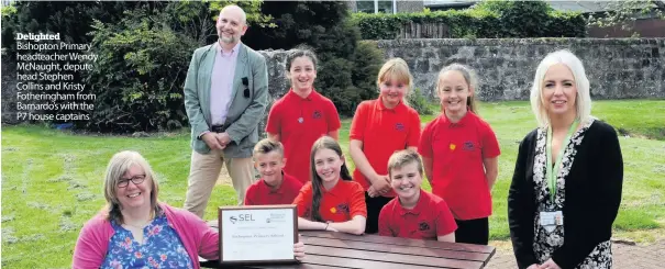  ??  ?? Delighted Bishopton Primary headteache­r Wendy McNaught, depute head Stephen Collins and Kristy Fotheringh­am from Barnardo’s with the P7 house captains