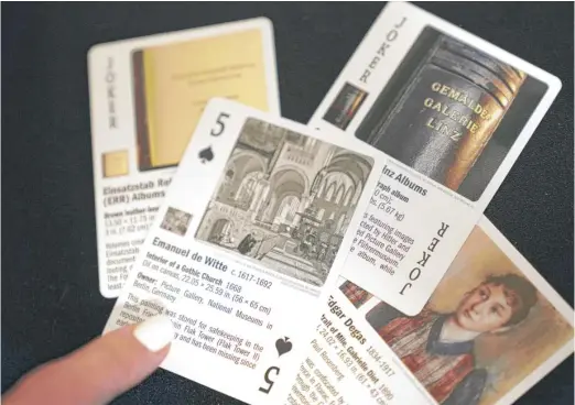  ?? LM OTERO/AP ?? Anna Bottinelli shows cards featuring missing works of art at the office of Dallas-based Monuments Men Foundation for the Preservati­on of Art last week.