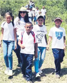  ??  ?? PRODUCCIÓN. Un grupo de niños de la escuela Marco Aurelio Soto de la aldea Plan Grande muestran el pepino que están logrando cosechar. La alcaldesa Diana Urbina apoya a los escolares.