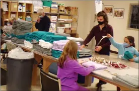  ?? BOB KEELER — MEDIANEWS GROUP ?? Abe Moyer, left rear, and other volunteers fold towels to be placed in the relief kits.