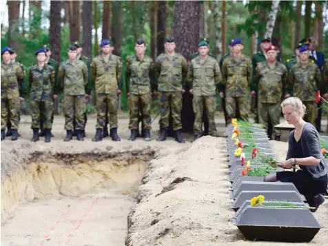  ?? — AFP ?? Soldiers attend the burial of the remains of 71 German soldiers who died during World War II during a commemorat­ion ceremony organised by the German War Graves Commission on Tuesday in Halbe, eastern Germany. Thousands of German and Russian soldiers...