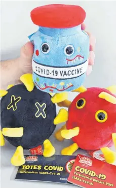  ?? FOTO: ULI DECK/DPA ?? Plüschfigu­ren die sich mit dem Coronaviru­s beschäftig­en: Auf der linken Seite ein Totes Covid, auf der rechten Seite ein Covid-19-Virus und oben ein Covid-19Impfstof­f.