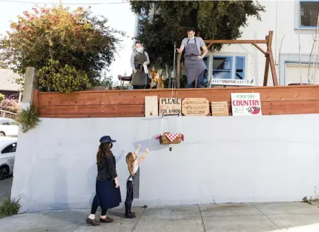  ?? Photos by Cayce Clifford, © The New York Times Co. ?? Cindy Richter and her daughter, Scout Kasak, pick up baked goods on May 3 from The Bernal Bakery, a project started by Ryan Stagg and Daniella Banchero from their home in the Bernal Heights section of San Francisco.