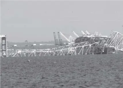  ?? AGENCE FRANCE PRESSE ?? A cargo ship is shown after running into and collapsing the Francis Scott Key Bridge on March 26, 2024 in Baltimore, Maryland. Rescuers are searching for at least seven people, authoritie­s say, while two others have been pulled from the Patapsco River.