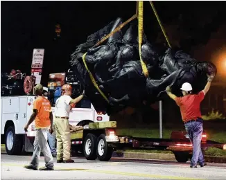  ?? JERRY JACKSON / THE BALTIMORE SUN VIA AP ?? Workers remove a monument dedicated to the Confederat­e Women of Maryland early Wednesday after it was taken down in Baltimore. Local news outlets reported that workers hauled several monuments away, days after a white nationalis­t rally in Virginia...