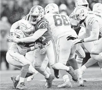  ?? BILLIE WEISS GETTY IMAGES ?? Austin Ekeler (30 of the Chargers finds no space to run while being tackled by Josh Uche of New England in the second quarter at Gillette Stadium last Sunday. Ekeler has 446 yards and four TDs on 126 carries.