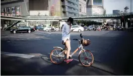  ??  ?? SHANGHAI: This picture in Shanghai shows a girl riding bicycle from a sharing company.—AFP