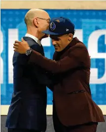  ?? GETTY IMAGES ?? Trae Young hugs NBA Commission­er Adam Silver after being drafted fifth overall by the Dallas Mavericks. Young later was traded to the Hawks with a draft pick for Luka Doncic.
