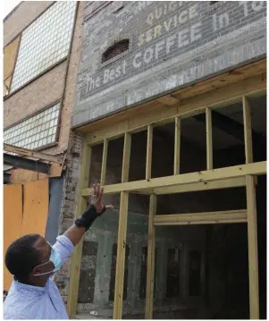  ?? (Pine Bluff Commercial/Dale Ellis) ?? Maurice Taggart points to signage that was revealed when the facade was removed from the front of the building at 324 Main St.