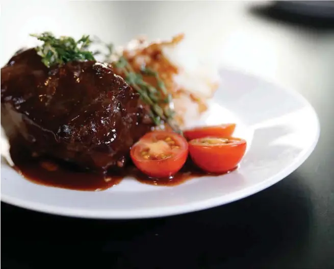  ?? NHAT V. MEYER/STAFF ?? Tony Santos elevates a holiday spread with braised short ribs and garlic mashed potatoes.