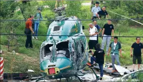  ?? THOMAS PETER / REUTERS ?? Rescuers and investigat­ors work at the site of a helicopter crash on Monday in Beijing in which four
people were injured.