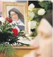  ??  ?? A nun prays beside the casket and photo of Sister Cecylia Roszak during her funeral in Krakow, Poland, on Thursday.
