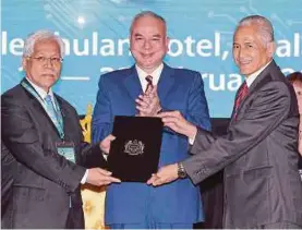  ?? PIC BY SAIFULLIZA­N TAMADI ?? Sultan of Perak Sultan Nazrin Muizzuddin Shah (centre) witnessing the handover of wakaf chair documents from Datuk Seri Idris Jusoh (left) to UM Vice-Chancellor Datuk Dr Abdul Rahim Hashim in Kuala Lumpur yesterday.