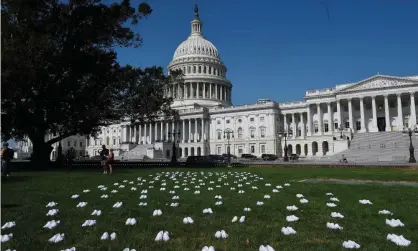  ??  ?? National Nurses United (NNU) displays white clogs outside the US Capitol to honor the nurses who have lost their lives to Covid-19, and to demand action from Congress. Photograph: Olivier Douliery/AFP/Getty Images