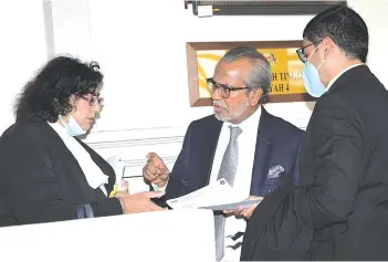  ??  ?? Shafee (centre) discussing with his colleagues after new trial dates have been set for his money laundering case.