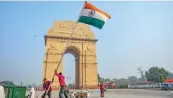  ?? — PTI ?? Workers fix the national flag near the India Gate in New Delhi.