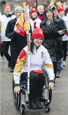  ?? DARREN STONE, TIMES COLONIST ?? Six-time Paralympic gold medalist Michelle Stilwell brings the torch to the B.C. legislatur­e as part of the cross-Canada relay tour.