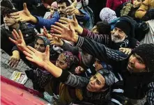  ?? Khalil Hamra/Associated Press ?? Volunteers pass out resources to people Wednesday in Antakya in southern Turkey. The death toll from Monday’s devastatin­g earthquake neared 12,000.