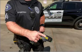  ?? PHOTO VINCENT OSUNA ?? Imperial Police Department Sgt. Max Sheffield holds out a X26 Taser, which IPD officers currently use, on Thursday at the IPD in Imperial. The department will be receiving new Tasers to replace its X26 models.