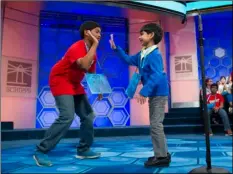  ??  ?? FROM RIGHT: Akash Vukoti, 6, of San Angelo, Texas, is offered support by Alex Iyer, 13, from Boerne, Texas, after he incorrectl­y spelled his word during the preliminar­y round three of the Scripps National Spelling Bee on Wednesday in National Harbor,...