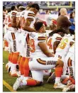  ?? ANDY LYONS / GETTY IMAGES ?? Cleveland Browns players stand and kneel as the national anthem is played Sunday before a game in Indianapol­is.