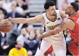  ?? FRANK GUNN THE CANADIAN PRESS ?? Denver Nuggets guard Jamal Murray, a native of Kitchener, protects the ball from Raptors forward Norman Powell in Toronto on Tuesday night.