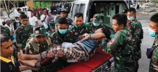  ?? - Reuters/Beawiharta ?? RESCUED: Indonesian soldiers lift up an injured woman after arriving at Tanjung hospital after earthquake hit on Sunday in North Lombok, Indonesia, August 7, 2018.