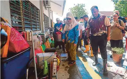  ?? (Foto Wan Nabil Nasir/bh) ?? Fadhlina meninjau peralatan sekolah yang rosak akibat ditenggela­mi banjir di Sekolah Menengah Kebangsaan Serigunong, Alor Setar, semalam.