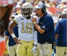  ?? HYOSUB SHIN / HSHIN@AJC.COM ?? “I think everyone knows what they’re doing. We’re keeping it really simple right now, so it’s kind of hard to mess it up,” says QB TaQuon Marshall (with coach Paul Johnson).