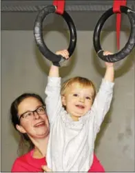  ?? MICHILEA PATTERSON — DIGITAL FIRST MEDIA ?? Dorian O’Connell helps her daughter Juniper, 2, do pull-ups with gym rings at the Pottstown Athletic Club for a No Excuse