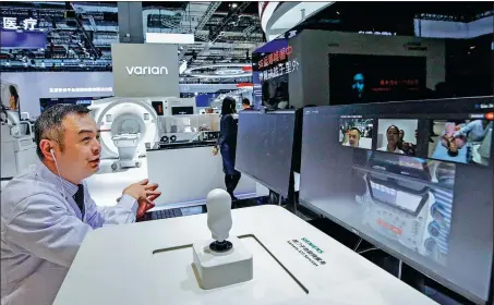  ?? ZHANG YUWEI / XINHUA ?? Using a 5G- enabled remote diagnostic tool, a doctor offers advice to users of an online healthcare system during a medical industry exhibition in Shanghai in November last year.