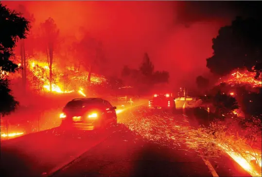  ?? ASSOCIATED PRESS ?? EMBERS FLY ACROSS A ROADWAY AS THE KINCADE FIRE BURNS through the Jimtown community of Sonoma County, Calif., on Thursday.