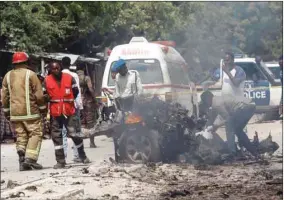  ??  ?? Rescuers, security and paramedics are seen at the scene of a car explosion near Benadir hospital in Mogadishu, Somalia yesterday.