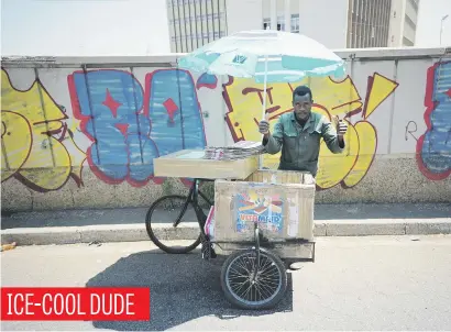  ?? Picture: Michel Bega ?? A vendor takes advantage of the hot spring weather in Johannesbu­rg to sell ice-cream to passersby on the Queen Elizabeth Bridge.