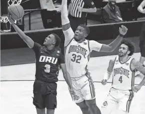  ?? MIKE DINOVO/USA TODAY SPORTS ?? Oral Roberts guard Max Abmas (3) shoots the ball against Ohio State forward E.J. Liddell (32) and guard Duane Washington Jr. (4) during the second half Friday in West Lafayette, Ind.