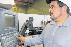  ?? CHRIS SHANNON/CAPE BRETON POST ?? Justin Lewis takes a look Friday at a computer numerical control milling machine at the Nova Scotia Power Makerspace located in the gymnasium of the former Holy Angels High School, now known as the New Dawn Centre for Social Innovation in north end Sydney. Lewis plans to start up his own general contractin­g company and will be looking to use some of the heavy machinery in carrying out some of his work.