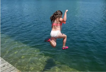  ?? DAVE JOHNSON
TORSTAR ?? Courtney Cowell jumps in the water at the Lincoln Street Docks in Welland to beat Wednesday’s sweltering heat.