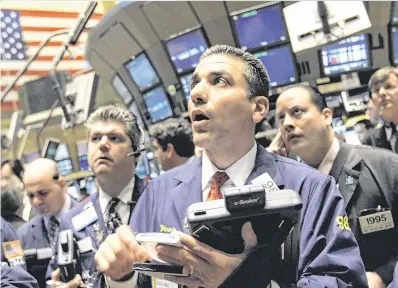  ??  ?? Traders react to market events on the floor of the New York Stock Exchange