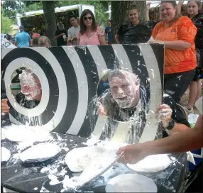  ?? Westside Eagle Observer/SUSAN HOLLAND ?? Adam Vore, Gravette coach and middle school teacher, and officer Josh Crane, one of Gravette’s school resource officers, still have grins on their faces after being hit with several pies. The “pie in the face” booth in Kindley Park at Saturday’s Gravette Day event was a popular fundraiser for the junior high cheerleade­rs.