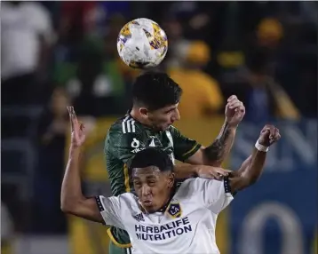  ?? RYAN SUN — THE ASSOCIATED PRESS ?? Galaxy defender Mauricio Cuevas, bottom, and Portland defender Claudio Bravo vie for a head ball in the first half Saturday.