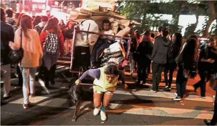  ??  ?? Pulling through: Silva pulling her cart loaded with recyclable­s, accompanie­d by her nine-year-old nephew Jean and her dog Bobby, on Paulista avenue in Sao Paulo, Brazil. — Reuters